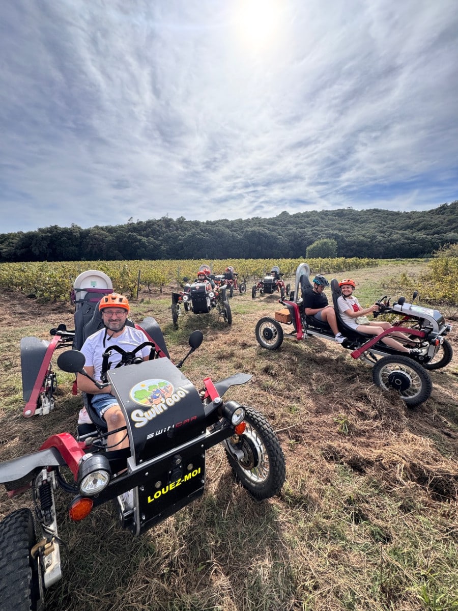 Balade en Swincar Swincool tout-terrain dans un vignoble avec des conducteurs souriants et équipés.