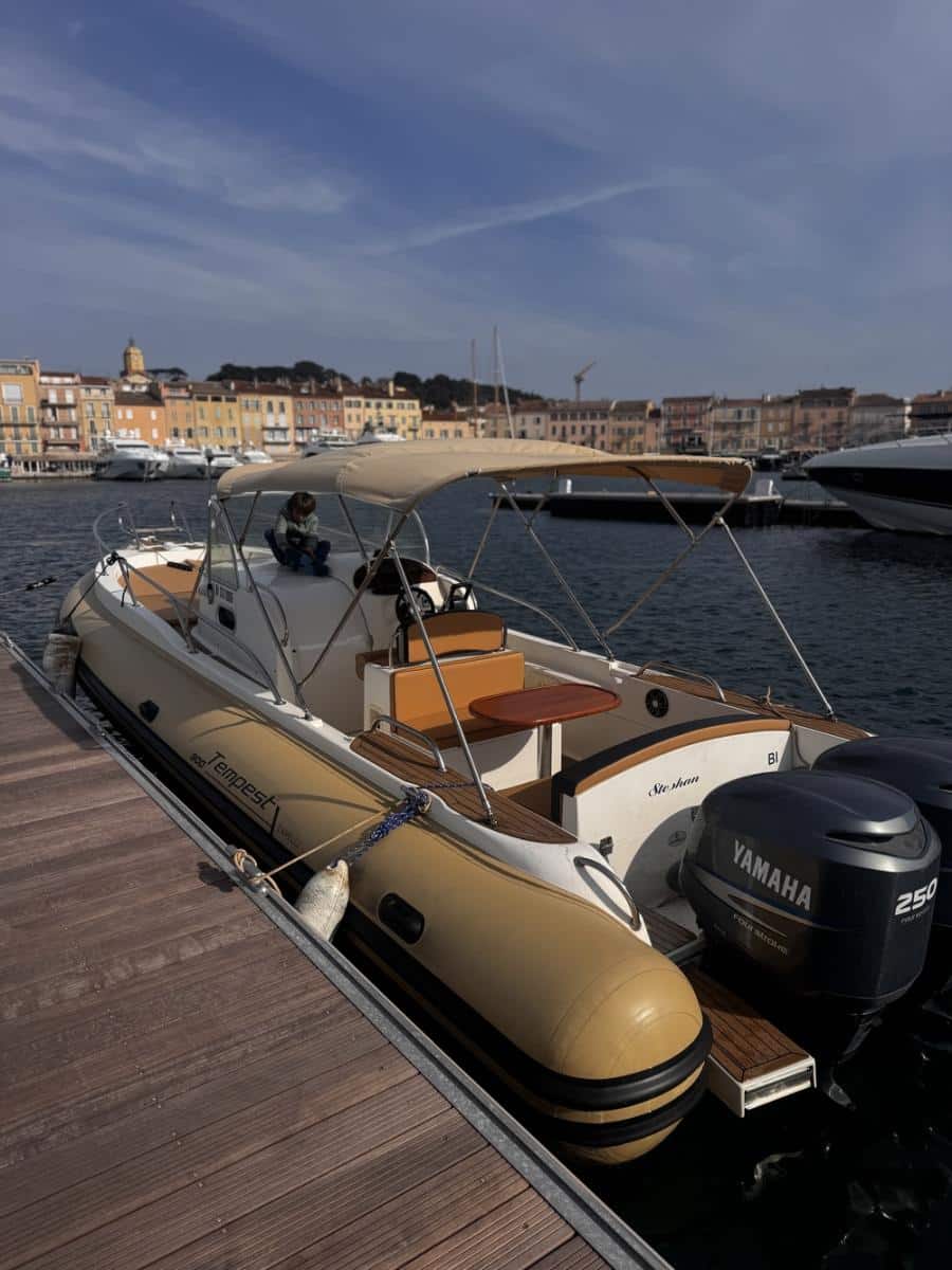 Bateau Capelli Tempest 800 amarré avec moteur Yamaha 250, enfant à bord dans un port de plaisance méditerranéen.