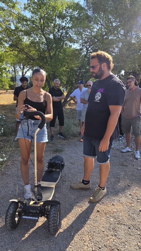 Démonstration du skate électrique tout-terrain Sterboard Femme présentant le skate électrique tout-terrain Sterboard à un groupe lors d'une démonstration en plein air.